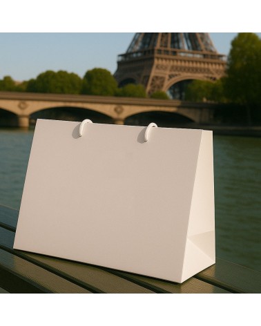 Sac cadeau blanc grand format Antarell présenté en main lors d’un événement professionnel